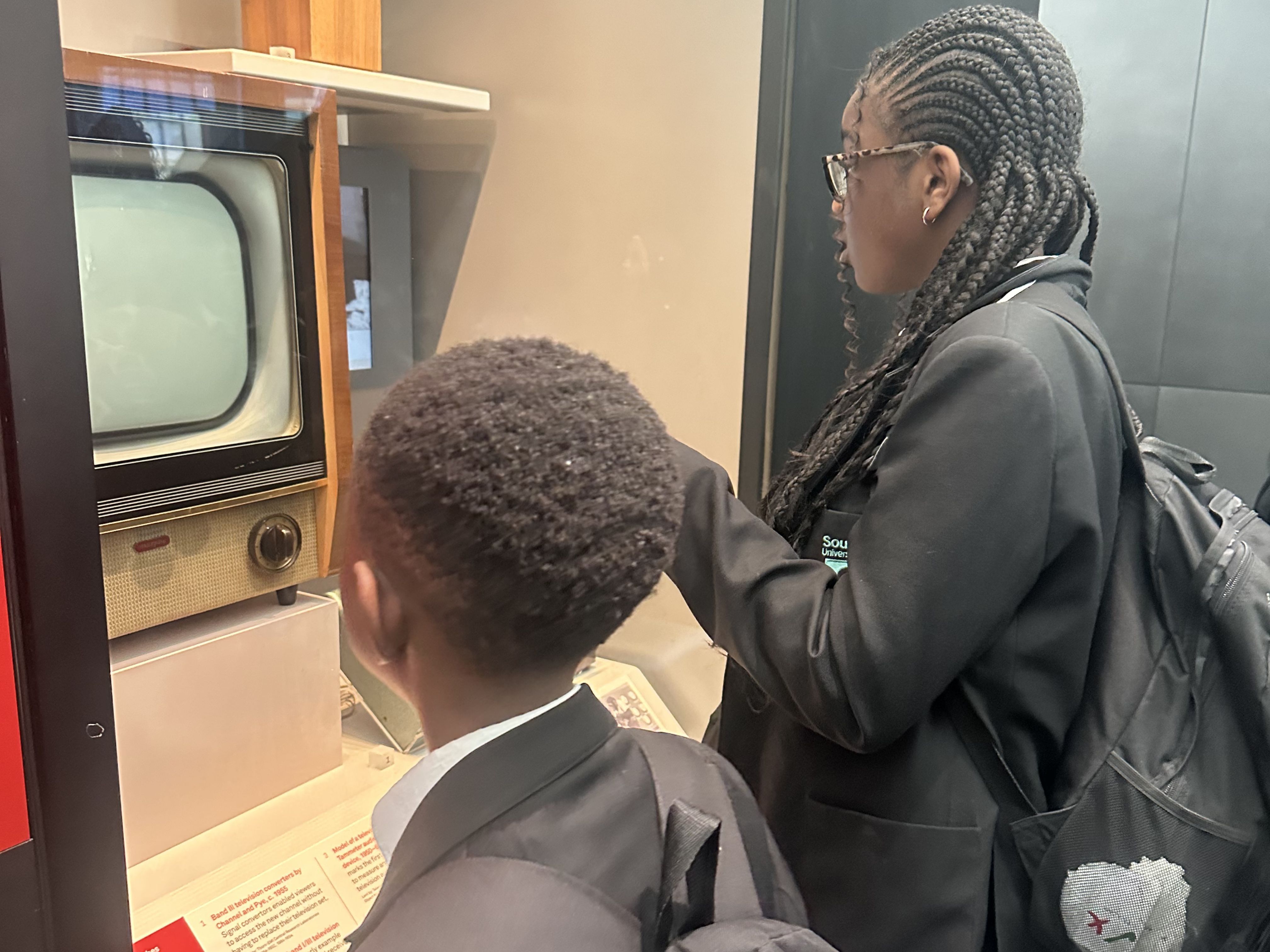 students interacting with old TV