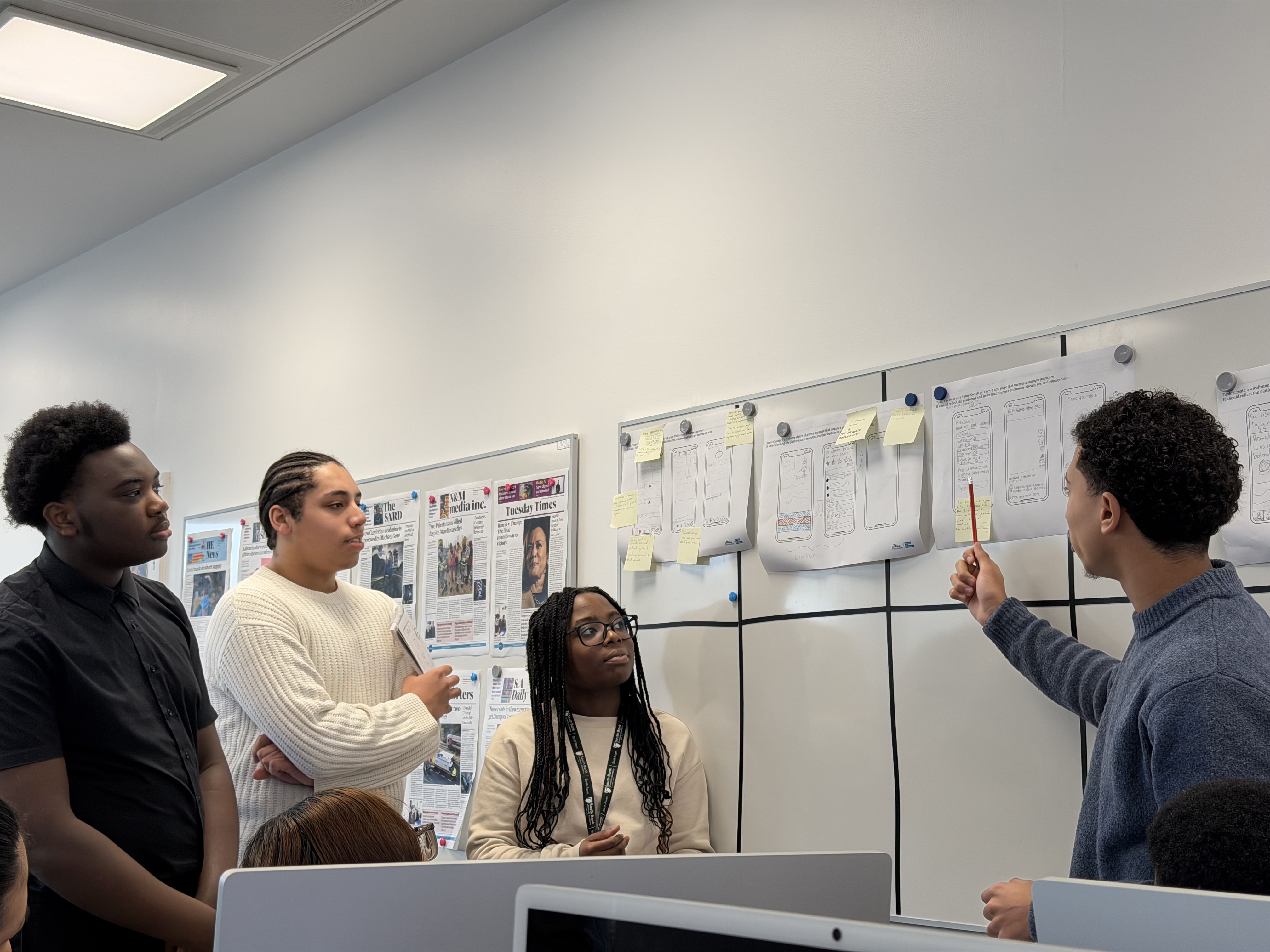 A group of students giving their presentation on their app interfaces