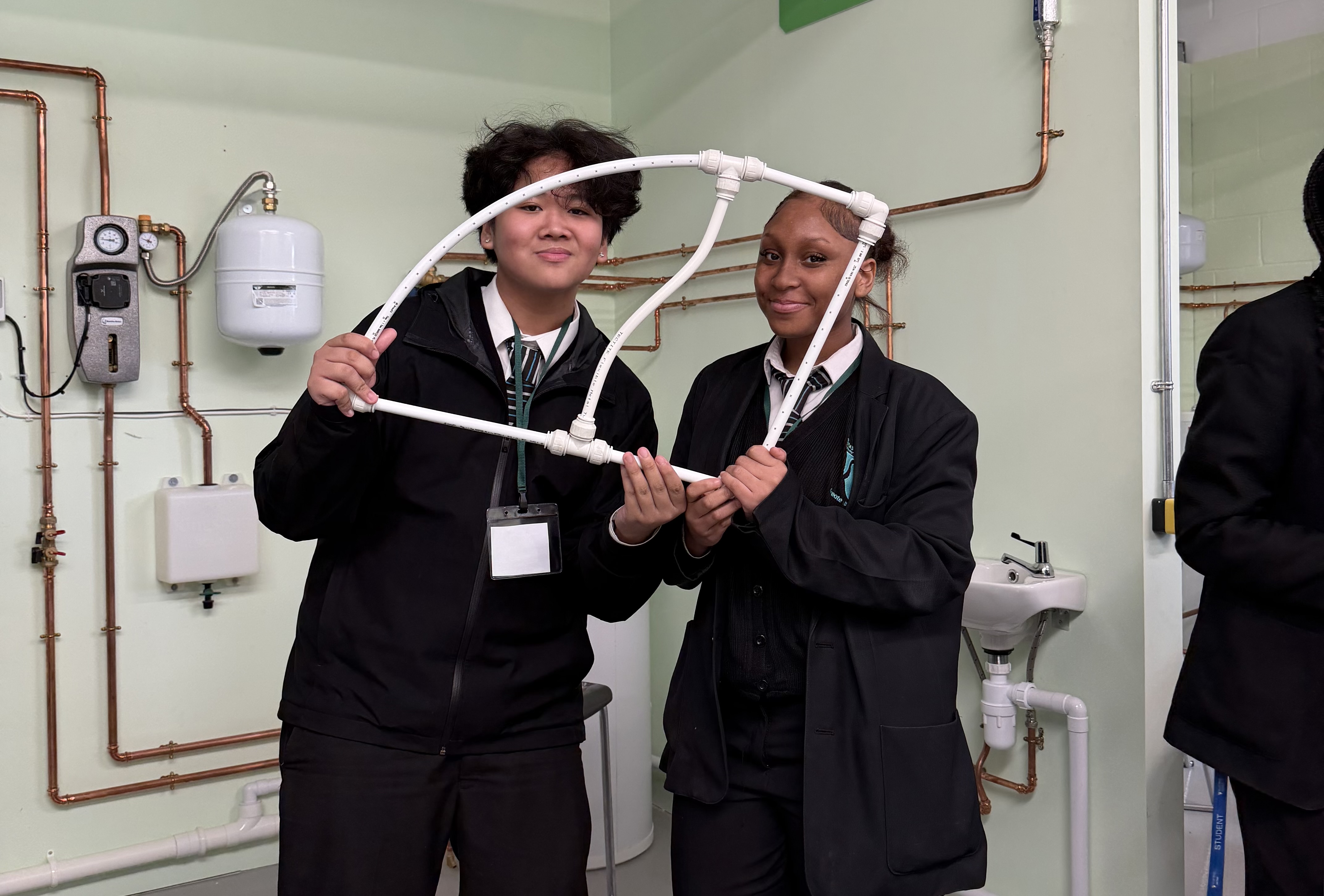 Students holding up their self constructed pipe model