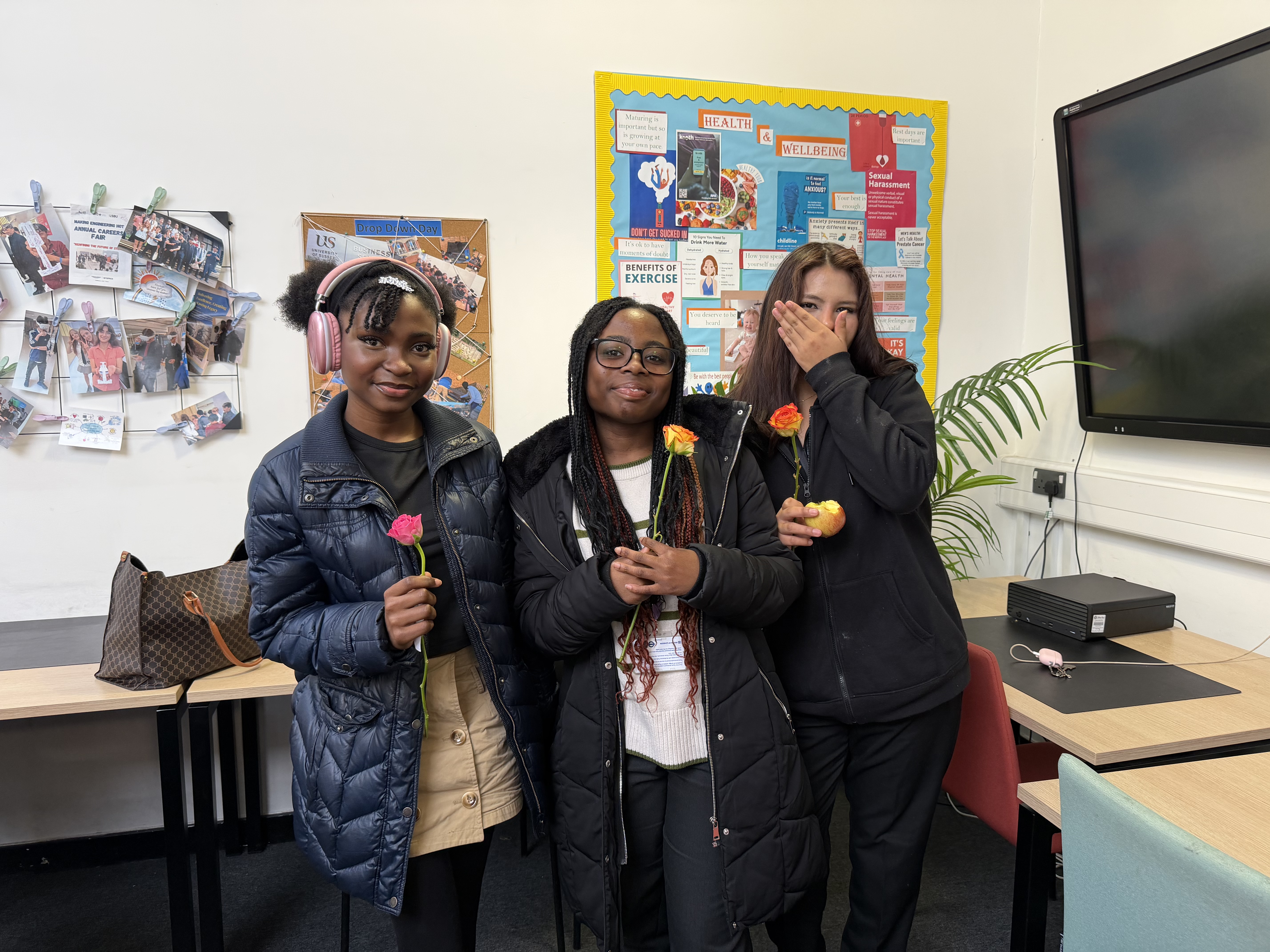 Students smiling with flowers in their hands