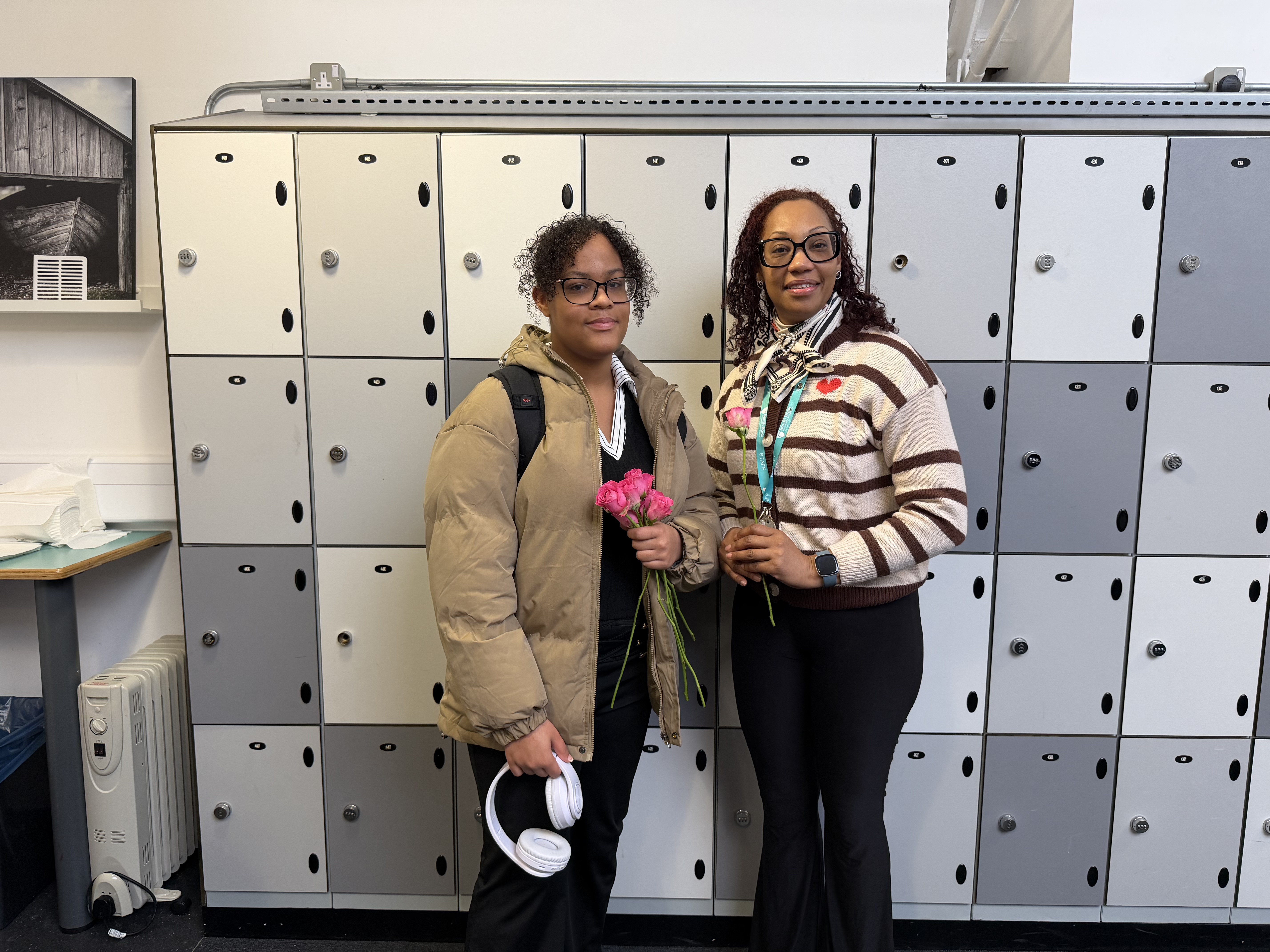Tutor and student taking photo with flowers