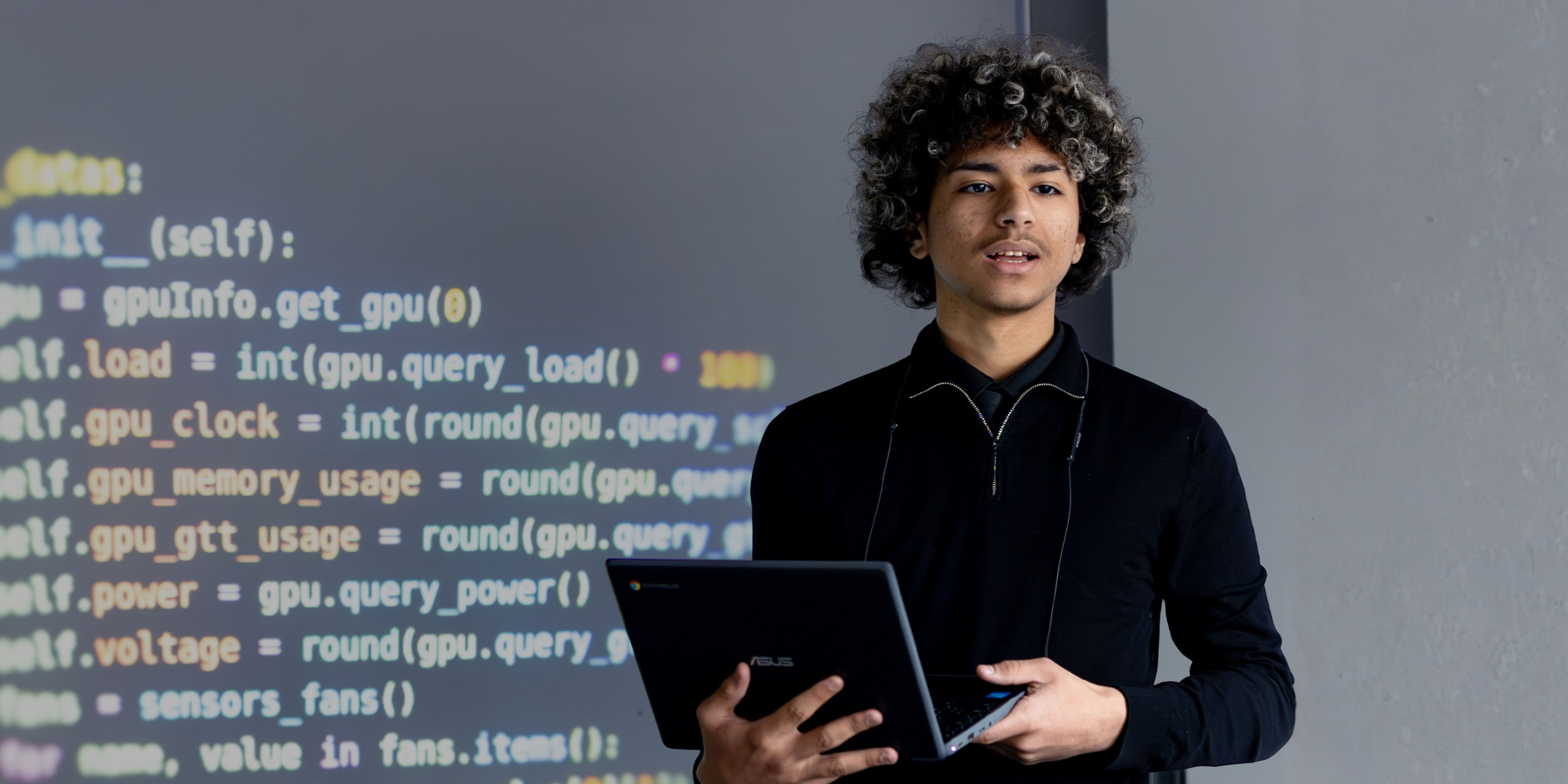 Student holding onto laptop during a presentation