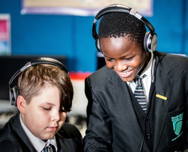 Smiling students wearing headphones
