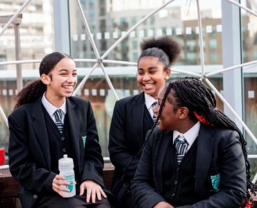 Three smiling students sat together