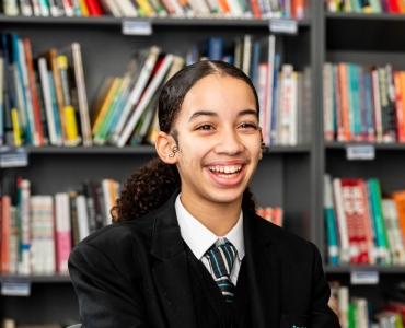 Smiling student sitting in library