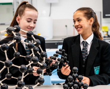 Students holding scientific model